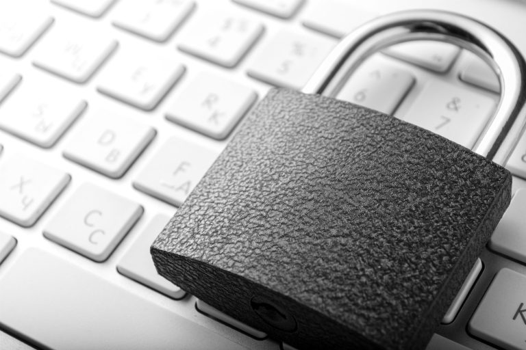 Schwarzes Vorhängeschloss auf einer Laptop-Tastatur.