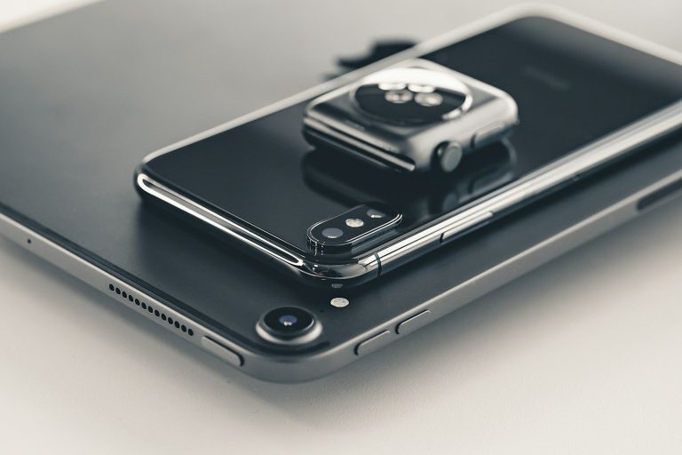 Smartphone und Smartwatch nebeneinander auf einem Tablet.