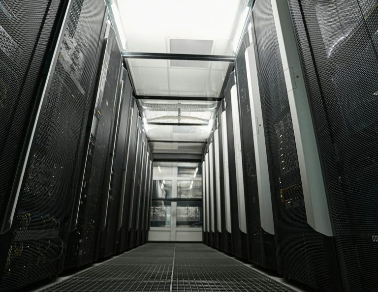 Korridor eines Rechenzentrums mit großen Server-Racks auf beiden Seiten.